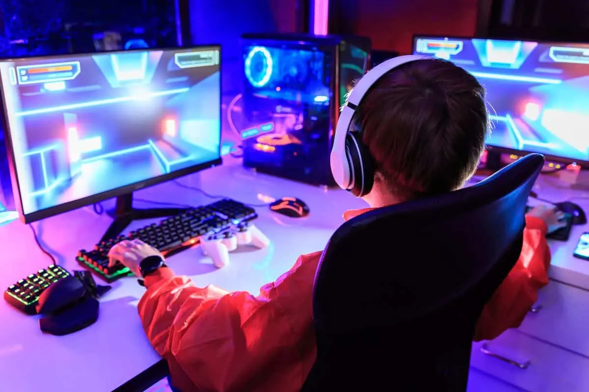 Criança jogando em frente a monitor gamer