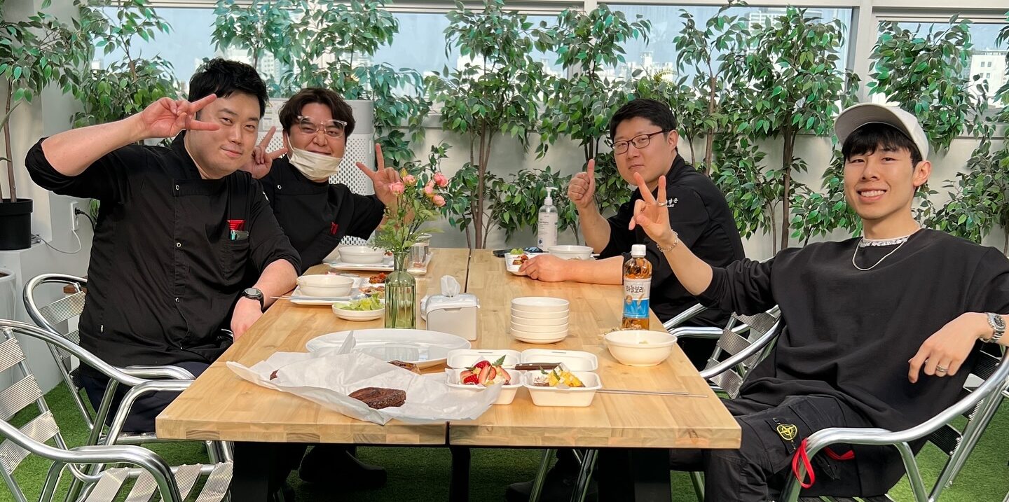 LoL: Cozinheiro da T1 revela o que os maiores campeões comem nas refeições 1 cozinheiros e produtor do documentário na mesa do refeitório da T1