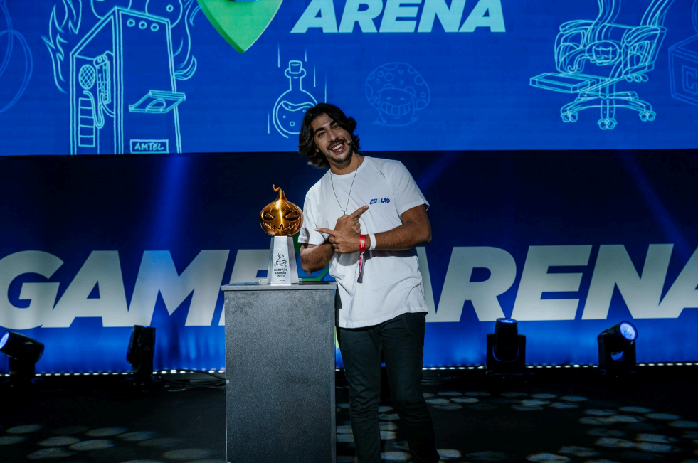 Baiano posando para foto com troféu do CBOLÃO de LoL