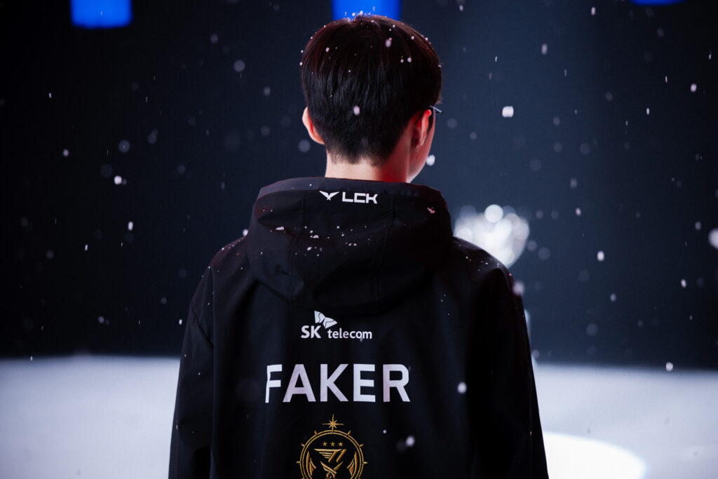jogaor de LoL, Faker posando para foto coberto por flocos de neve. marco histórico