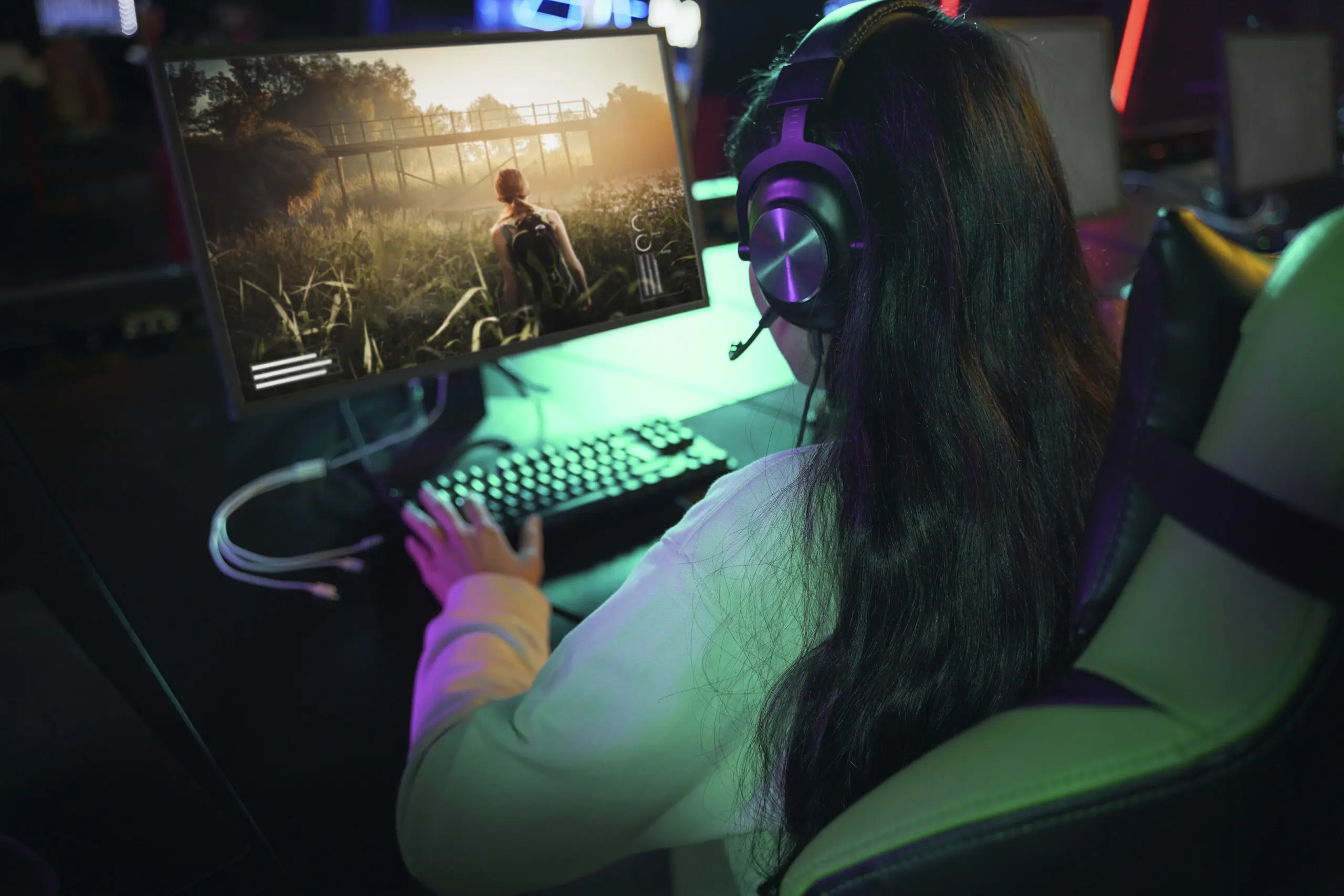 Mulher jogando em um computador gamer com um setup completo.