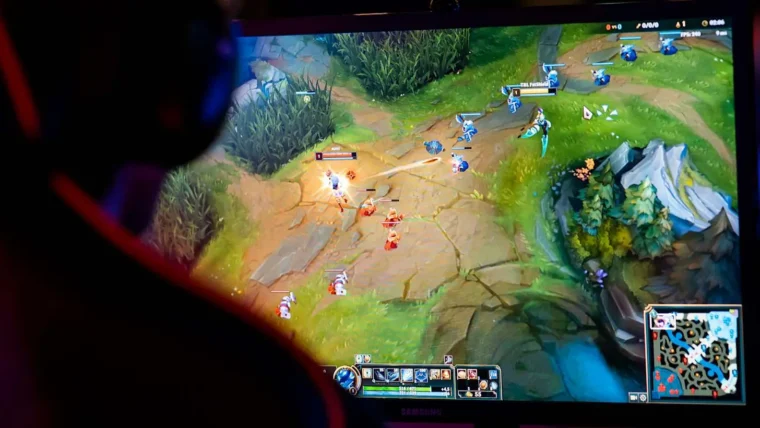 Monitor com a tela focando em um dos mapas de LOL.