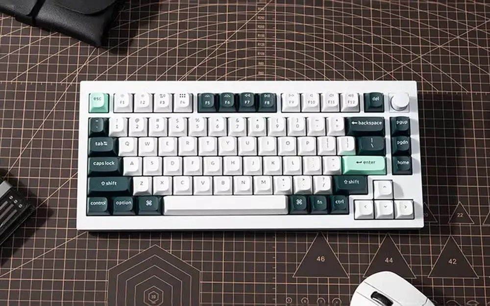 Teclado magnético compacto de cor branca, visto de cima sobre uma mesa de corte.